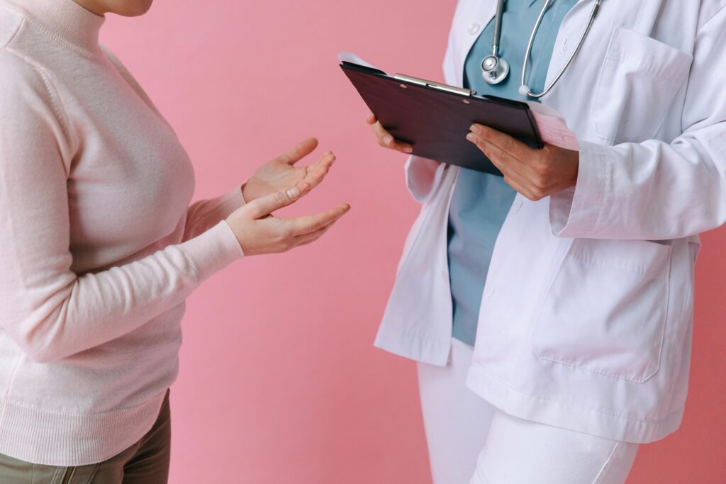pexels-photo-7659869-7659869 Close-up of a patient consulting a doctor with a clipboard in a medical setting.